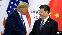 资料照片：特朗普总统与习近平主席在大阪20国集团峰会期间握手（2019年6月29日）