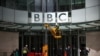 FILE - Repairmen work next to a sign at the British Broadcasting Corporation (BBC) headquarters in London, March 13, 2023. 