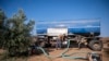 Dimitris Papadakis Jr, turns the valve on a container that is connected to a small generator, to water an olive grove in the village of Nea Silata at Halkidiki peninsula, northern Greece, Aug. 19, 2024. 