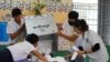 Election officials count ballots at a polling station on the day of Cambodia's general election, in Phnom Penh, Cambodia, July 23, 2023.

