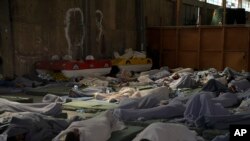 Sobreviventes de um naufrágio dormem num armazém no porto da cidade de Kalamata, cerca de 240 quilómetros a sudoeste de Atenas, quarta-feira, 14 de junho de 2023