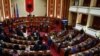 Anggota parlemen Albania dari kelompok oposisi melakukan protes di dalam parlemen selama sesi yang mencakup pemungutan suara yang akan mengizinkan Italia membangun pusat pemrosesan migran di wilayah Albania, di Tirana, Albania, 22 Februari 2024. (REUTERS/Florion Goga)