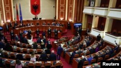 Anggota parlemen Albania dari kelompok oposisi melakukan protes di dalam parlemen selama sesi yang mencakup pemungutan suara yang akan mengizinkan Italia membangun pusat pemrosesan migran di wilayah Albania, di Tirana, Albania, 22 Februari 2024. (REUTERS/Florion Goga)