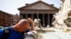 A man cools off at a fountain near the Pantheon, during a heat wave across Italy, in Rome, July 19, 2023.