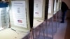 FILE - A lone voter fills out a ballot alongside a row of empty booths at a polling station in the Terrace Park Community Building on Election Day in Cincinnati, Ohio, Nov. 8, 2016.