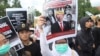 Seorang pengunjuk rasa mengacungkan poster bergambar Presiden Joko Widodo yang dirusak saat aksi protes, menuntut pemilihan presiden yang adil di Yogyakarta, Senin, 12 Februari 2024. (AP/Slamet Riyadi)