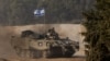 Một người lính Israel lái xe bọc thép chở quân (APC) gần biên giới với Gaza, sau khi thỏa thuận ngừng bắn tạm thời giữa Israel và nhóm Hồi giáo bảo thủ người Palestine Hamas hết hạn, ở Israel, ngày 1 tháng 12 năm 2023.