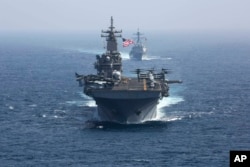 FILE - The amphibious assault ship USS Kearsarge and the Arleigh Burke-class guided-missile destroyer USS Bainbridge sail in formation as part of the USS Abraham Lincoln aircraft carrier strike group in the Arabian Sea. President Joe Biden has chosen Adm. Lisa Franchetti to lead the Navy, a senior administration official said July 21, 2023. (U.S. Navy via AP)