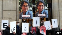 FILE - In this Jan. 13, 2022 photo, colleagues of academic Fariba Adelkhah hold placards in Paris in support following Iran's decision to send her back to prison after a period of house arrest. On Feb. 10, 2023, she was released from prison. 