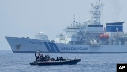 资料照片：在美国、日本和菲律宾三边海岸警卫队演习期间，一艘菲律宾海警的硬底橡皮艇经过日本海上保安厅的“秋津洲”号。（2023年6月6日）