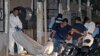 Forensic personnel remove the body of one of the eleven people killed in a pool hall in Choloma, about 180 km north of Tegucigalpa, early on June 25, 2023. 