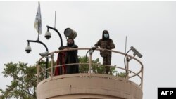 塔利班士兵在美国驻阿富汗大使馆外的塔楼上进行监视。（2022年4月12日）