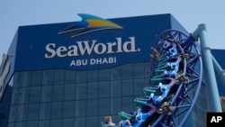 Para pengunjung menikmati roller coaster di SeaWorld di Pulau Yas, Abu Dhabi, Uni Emirat Arab, 26 Mei 2023. (AP Photo/Nick ElHajj)