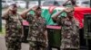 Des membres de l'armée kenyane font le salut militaire à côté du cercueil transportant le corps du chef des forces de défense kenyanes, le général Francis Omondi Ogolla, au complexe sportif d'Ulinzi à Nairobi, le 20 avril 2024. (Photo par LUIS TATO / AFP)