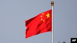 Bendera nasional China berkibar di Lapangan Tiananmen di Beijing Kamis, 14 Juni 2018. (Foto: AP)