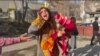 This image grab from a UGC video posted outside Iran on March 15, 2023, shows Iranian activist and journalist Sepideh Gholian walking with a bouquet of flowers outside the walls of Evin prison in Tehran, following her release. She was later rearrested.