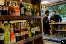 Orang-orang membeli alkohol di toko minuman keras di Bagdad, Irak, Kamis, 9 Maret 2023. (Foto: AP)