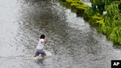 ট্যাম্পা, ফ্লোরিডার প্লাবিত রাস্তায় একজন হাঁটছেন। ৩০ আগস্ট ২০২৩। 