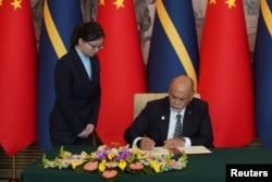 Menteri Luar Negeri dan Perdagangan Nauru Lionel Aingimea menandatangani Komunike Bersama tentang Dimulainya Kembali Hubungan Diplomatik antara Republik Rakyat China dan Republik Nauru, di Beijing, 24 Januari 2024. (Foto: Andrea Verdelli/Pool via REUTERS)