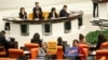 Anggota parlemen Turki dari partai Kebebasan Sosial (latar depan kiri), dan Platform Solidaritas Sosialis memegang poster bertuliskan dalam bahasa Turki: "Tidak ada pendudukan, tidak ada perang untuk NATO!" di Parlemen Turki di Ankara, 23 Januari 2024. (AP/Ali Unal)