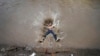 A boy jumps into a canal on a hot day in Jammu, India, June 20, 2023. Many parts of India are experiencing scorching heat this summer. 
