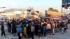 FILE - Migrants wait at Sfax port, after being stopped by Tunisian coast guard at sea during their attempt to cross to Italy, Apr. 26, 2023. 