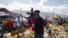FILE - Barbecue, the leader of the G9 and Family gang, stands next to garbage to call attention to the conditions people live in as he leads a march against kidnapping through La Saline neighborhood in Port-au-Prince, Haiti, Oct. 22, 2021.