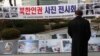FILE - A man watches photos showing North Korean children suffering from famine at a photo exhibition in Seoul, South Korea, Feb. 27, 2014.