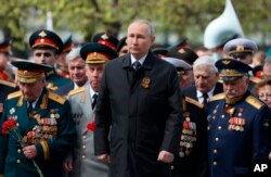 ប្រធានាធិបតី​រុស្ស៊ី លោក Vladimir Putin ចូលរួម​ក្នុង​ពិធី​ដាក់​កម្រង​ផ្កា​នៅ​ចេតិយ​ទាហាន បន្ទាប់​ពី​ការ​ដើរ​ក្បួន​ព្យុហយាត្រាខួប​ទី ៧៧ នៃ​ការ​បញ្ចប់​សង្គ្រាម​លោក​លើក​ទីពីរ នៅ​ទីក្រុង​មូស្គូ ប្រទេស​រុស្ស៊ី ថ្ងៃទី៩ ខែឧសភា ឆ្នាំ២០២២។ (Sputnik, Kremlin Pool Photo via AP)