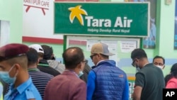 Papan nama Tara Airlines terpasang sementara para pendaki bersiap untuk operasi SAR dari Bandara Internasional Tribuvan di Kathmandu, Nepal, Minggu, 29 Mei 2022. Pesawat Tara Airlines dengan 22 penumpang hilang pada Minggu saat menerbangi rute popular di pegunungan Nepal.