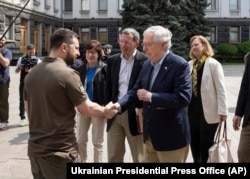 El presidente de Ucrania, Volodymyr Zelenskyy, a la izquierda, le da la mano al líder de la minoría del Senado de Estados Unidos, Mitch McConnell, en Kiev, el 14 de mayo de 2022.