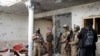 Para kombatan Taliban memeriksa sebuah rumah setelah baku tembak selama delapan jam antara Taliban dan ISIS saat Taliban menggerebek persembunyian militan ISIS di luar Jalalabad, timur Kabul, Afghanistan, 30 November 2021. (Foto: Shir Shah Hamdard/AP Photo)