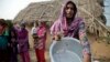A village woman displays a vessel damaged by gunfire allegedly from the Pakistan side of the border at Jora Farm village in the India-Pakistan border Ranbir Singh Pura region, about 35 kilometers (22 miles) from Jammu, India, Aug. 23, 2014.