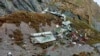 Puing-puing pesawat yang ditemukan di lereng gunung di Nepal hari Senin (30/5). 