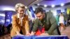 Presiden Ukraina Volodymyr Zelenskyy (kanan) dan Presiden Komisi Eropa Ursula von der Leyen menulis keinginan mereka pada bendera Ukraina saat berlangsungnya KTT UE-Ukraina di Kyiv, Ukraina, Kamis, 2 Februari 2023. ((Kantor Pers Kepresidenan Ukraina via AP)