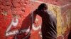 A drug addict leans on a wall after injecting himself with a dose of heroin on a street in Rawalpindi, Pakistan, Feb. 14, 2012.