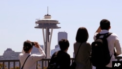 Turistas observan la Space Needle en Seattle, Washington.