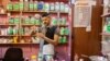 Hassan Abed Ali mixes different liquids meant for treatments, at his shop in Baghdad, Iraq, June, 11, 2023