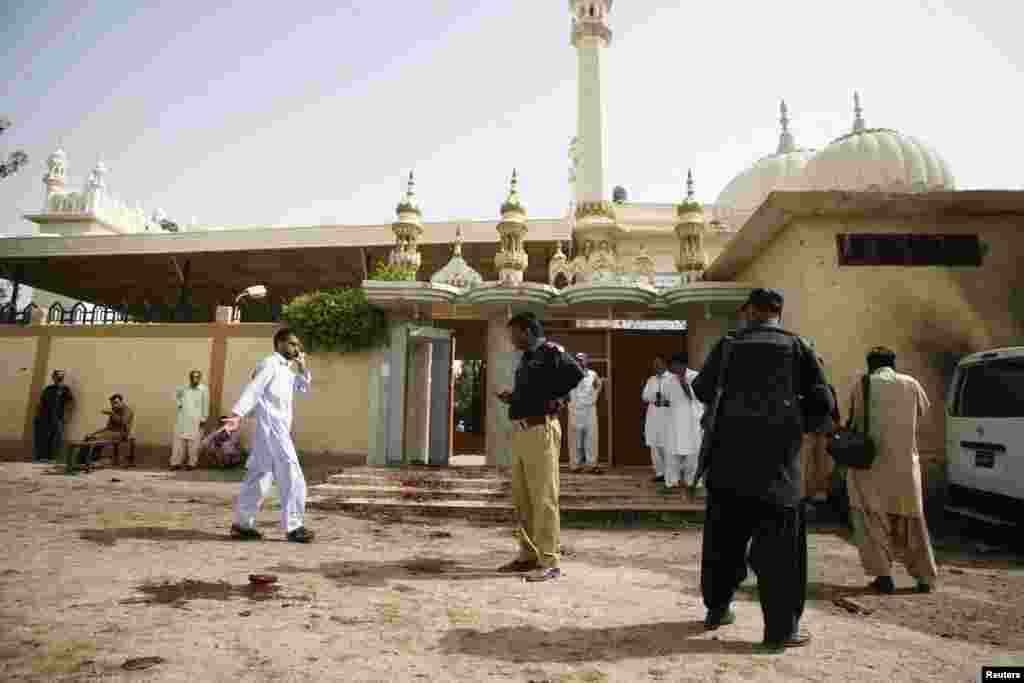 Security officials gather at the site of a bomb attack in Quetta, Pakistan, August 8, 2013. 