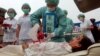 Members of Falun Dafa practitioners simulate organ harvesting in a mock Chinese labor camp in protest against China's suspected abuse and killing of Falun Gong members, Sunday, April 23, 2006, in front of the Presidential Office in Taipei, Taiwan. (AP Photo/Chiang Ying-Ying)
