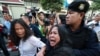 A friend, center, tries to help as an anti-coup protester, left, is detained by a Thai police officer during a protest on a street in Bangkok, Thailand Saturday, May 24, 2014.