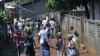 Residents of the mostly Peul suburb of Bambeto, Conakry, walk back to their homes behind barricades they set after a shooting incident, 17 Nov 2010