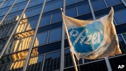 A Pfizer flag is displayed in front of world headquarters in New York, Nov. 23, 2015.