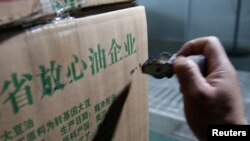 2018年7月4日，在中国山东省曲阜市，在粮油工业和进出口公司的工厂，瓶装大豆油的盒子上印着“放心油企业”“原料产国：美国”。