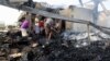 Yemeni men inspect damage at a factory allegedly targeted by Saudi-led coalition airstrikes in the Red Sea town of Hodeidah, July 27, 2018. 