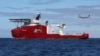 In this April 9, 2014 photo provided by the Australian Defense Force, a Royal Australian Air Force AP-3C Orion flies past Australian Defense vessel Ocean Shield on a mission to drop sonar buoys to assist in the acoustic search of the missing Malaysia Airl