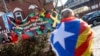 Un hombre llevando una bandera catalana camina cerca de la prisión de Neumünster donde permanece el expresidente Carles Puigdemont. La pancarta dice "Libertad a los prisioneros políticos en España".