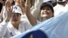Sam Rainsy party supporters greet onlookers at a busy market during an election rally in the capital Phnom Penh, in 2008.