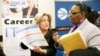 FILE - Recruiter Valera Kulow, left, speaks with job seeker Monic Spencer during a career fair in Dallas, Texas, Jan. 22, 2014.
