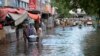 People wade through a flooded road during heavy monsoon rains in Hyderabad, Pakistan, on Aug. 30, 2024.